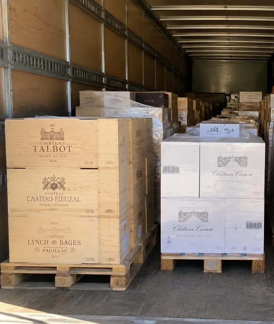 Marchandises de valeur : des caisses de vin français en bois et en carton, filmées sur palettes dans la remorque.